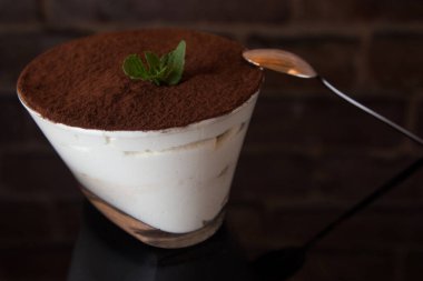 Tiramisu yakın plan siyah ayna arka plan, bir kaşık ile.