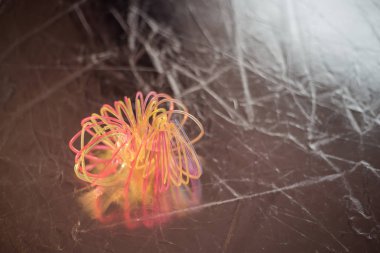 Kırık, karmakarışık plastik bir oyuncak karanlık arka planda yatıyor. 