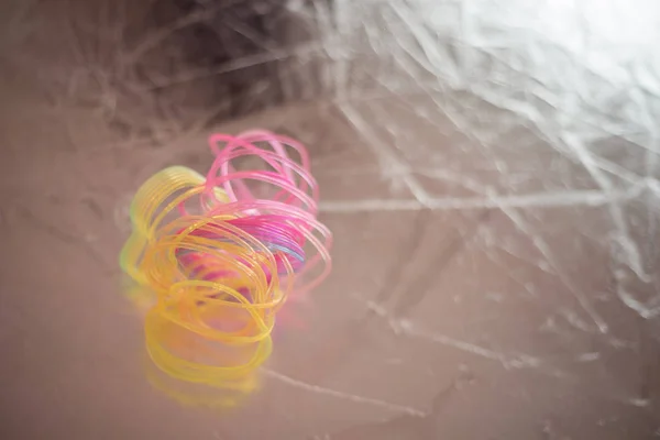 Kırık, karmakarışık plastik bir oyuncak karanlık arka planda yatıyor. 