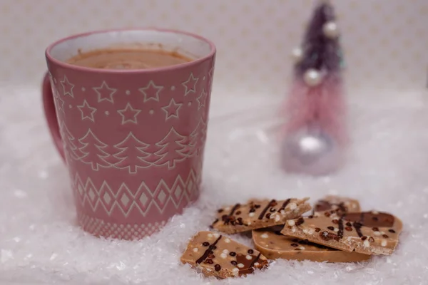Różowa filiżanka kakao i czekolady w śniegu. — Zdjęcie stockowe