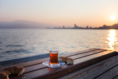 Geleneksel Türk kadehinde çay ve şafakta Türk simidi.