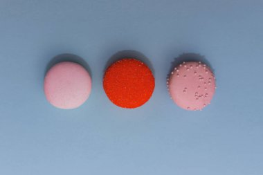 Düz zemin üzerinde üç renkli badem kurabiyesi.