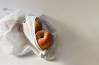 Elmalar elmanın içinde, güneş ışığında, gölgeli. Moda çevre dostu yeniden kullanılabilir şeyler kavramı. Yakın çekim, alanın derinliği, metin için yer