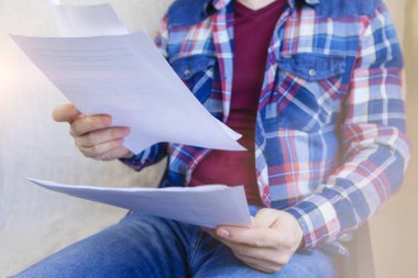 Kareli gömlek giyen adam belgelerle çalışıyor, kağıtlar evde. Uzaktan kumanda. Online eğitim. Karantinaya alın. Kendini soyutlama. Serbest meslek hayatı.