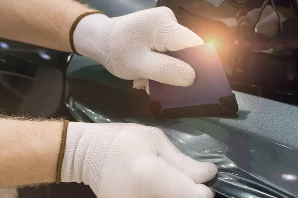 Özel bir aletle özel bir araba ve vinil film yapıştırma uzmanı. Araba bakımı. Araç bakımı. Yakın çekim alan derinliği.