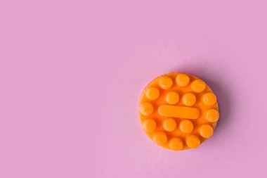 Cilt bakımı kozmetik. Pembe arkaplanda, yazı için yeri olan turuncu masaj sabunu görünümü. 