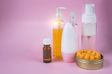 Cilt bakım kozmetik seti. Yüz yıkama jeli, masaj sabunu, deodorant, makyaj spreyinde gerekli yağ. Metin için yeri olan pembe arkaplanda ön görünüm. 