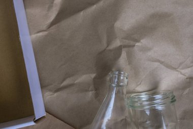 Geri dönüşümlü atık. Cam şişe, kutu ve el çantası. Sıfır atık. El işi kağıdının üzerine yatmış, mesaj için yer açılmış. Plastik propagandayı durdurun. Çöp ayıklama.