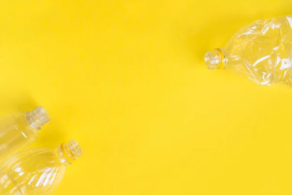 Plastic bottles top view on yellow background with copy space. Stop plastic concept. Say no to plastic. Garbage sorting. Recycling garbage. Single-use plastic objects. Ecological pollution.