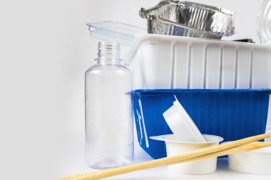 Plastik atık şişeleri ve kaplar, yemek çubukları ve alüminyum kaplar. Beyaz arka planda çöp geri dönüşümü Plastik konsepti durdurun. Çöp ayıklama. Tek kullanımlık plastik nesneler. Ekolojik kirlilik.