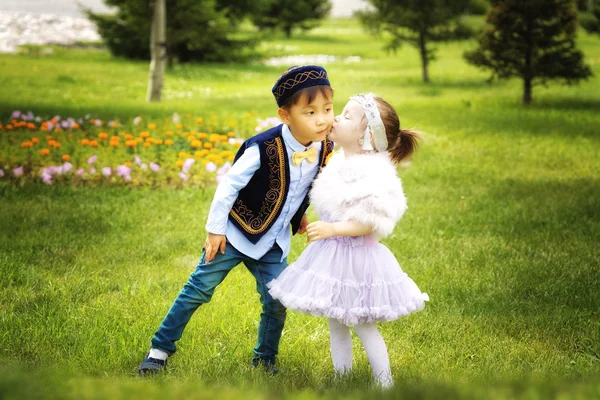 Kazakh pequeño niño y niña juntos jugando en el parque de verano —  Fotos de Stock