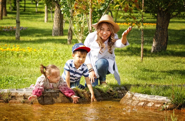 Kazakiska mamma med barn. Son och dotter i parken sommaren — Stockfoto