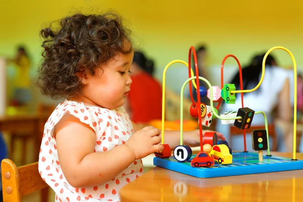 Kasachisches lockiges Mädchen spielt im Entwicklungszentrum für Kinder — Stockfoto