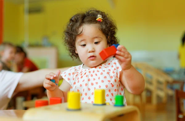 Kazakh Curly Girl spiller på barneutviklingssenteret. – stockfoto