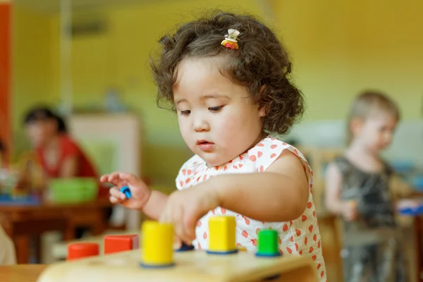 Kazakh curly girl playing in kids development center — Stock Photo, Image