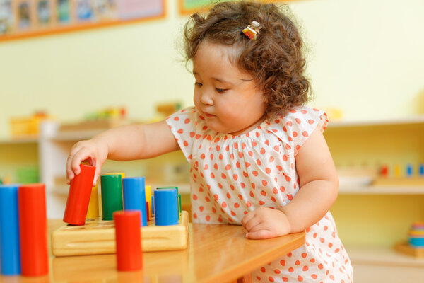 kazakh curly girl playing in kids development center