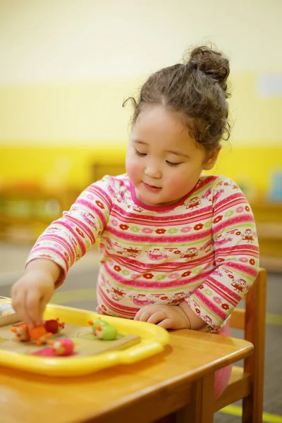 Kasachisches lockiges Mädchen spielt im Entwicklungszentrum für Kinder — Stockfoto