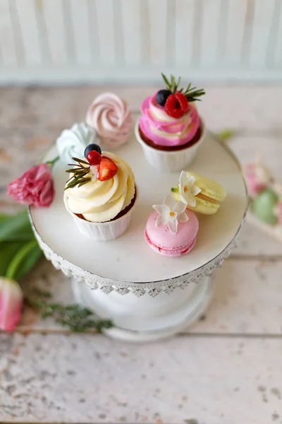 Cupcakes with berries and flowers — Stock Photo, Image