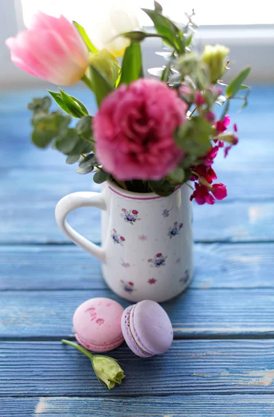 Bukiet kwiatów z makaroniki na drewnianym stole — Zdjęcie stockowe