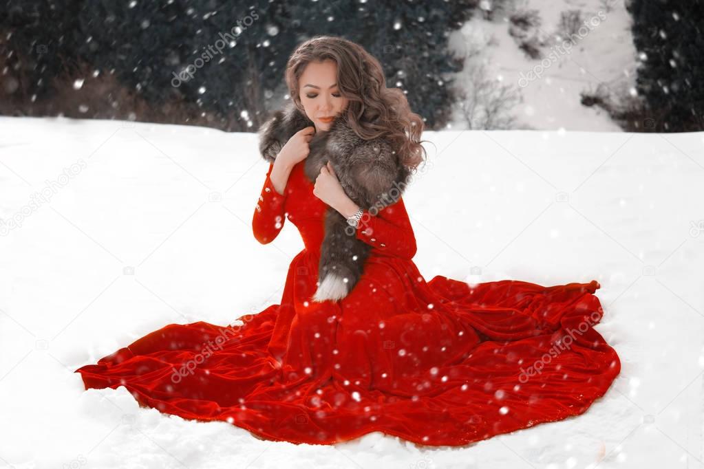 Beautiful kazakh woman in red dress on the snow