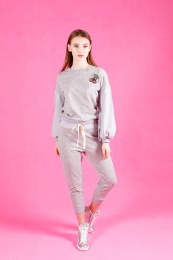 Studio gri ve pembe arka plan üzerinde poz güzel genç kadın