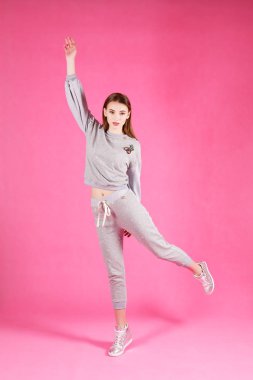 Studio gri ve pembe arka plan üzerinde poz güzel genç kadın