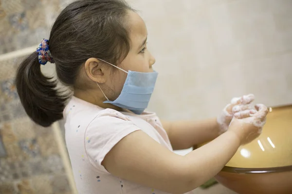 Pretty little asian kazakh girl in mask washing her hands. Person, Man, woman in mask.