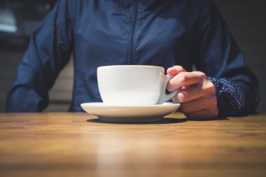 Kahve fincanı tablo Cafe restaurant üzerinde tutan hipster el 