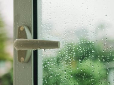 Raindrop on window with Handle Blur tree background Rainy Season clipart