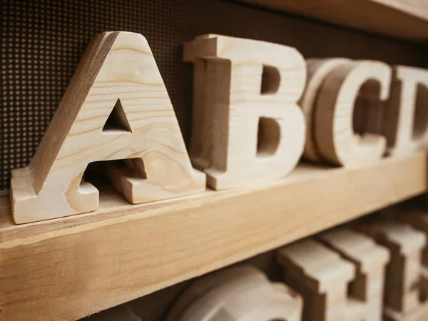 Tipo de alfabeto de madeira Fornecimento de artesanato na prateleira de madeira — Fotografia de Stock