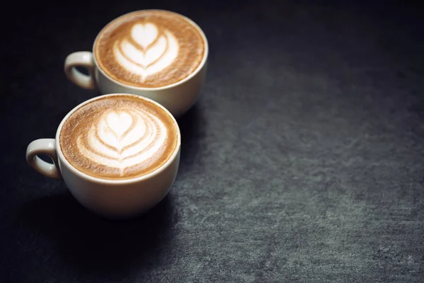 Duas xícaras de café no fundo rústico preto — Fotografia de Stock