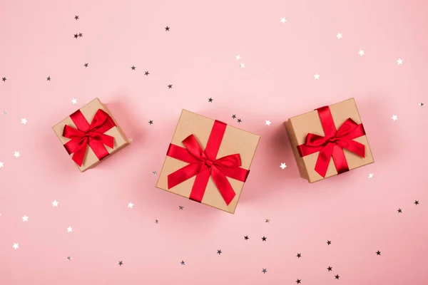 Three presents with red bow on pink