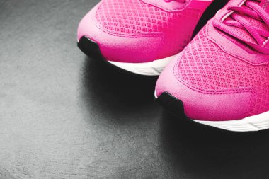 Siyah arka plan üzerine pembe spor ayakkabı