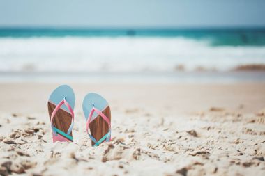 Trendy slippers on the sandy beach.