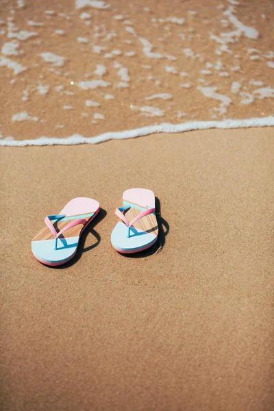 Μοντέρνα παντόφλες πάνω στην αμμώδη παραλία. — Φωτογραφία Αρχείου