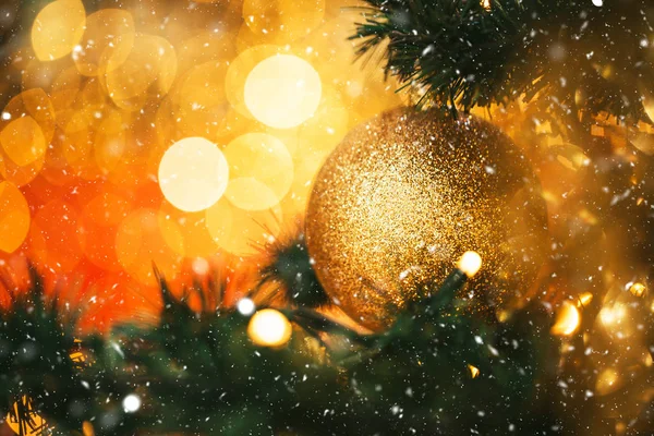 Fir branch with ball and festive lights — Stock Photo, Image
