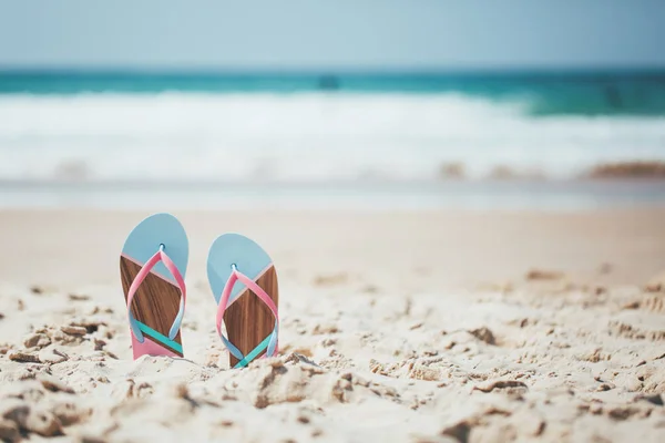 Trendy slippers on the sandy beach. Royalty Free Stock Photos