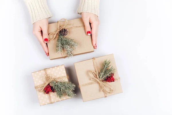Női kéz és három karácsonyi ajándék dobozok — Stock Fotó