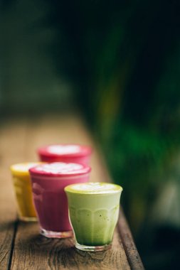 İki trendy pancar lattes latte sanat ve çiçek yaprakları üzerinde köpük ile.