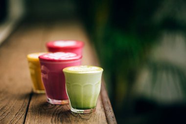 Trendy multicolored lattes with beetroot, avocado and turmeric tastes clipart