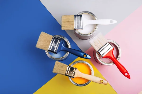 Four open cans with brushes on them on bright symmetry background. — Stock Photo, Image