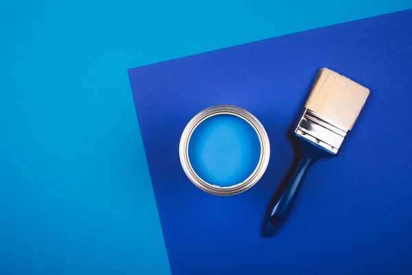 Pensla på öppen burk blå färg på blå bakgrund. — Stockfoto