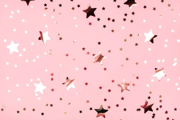 Estrelas douradas brilham sobre fundo rosa . — Fotografia de Stock