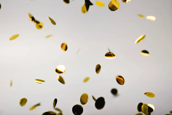 Golden falling confetti on grey — ストック写真