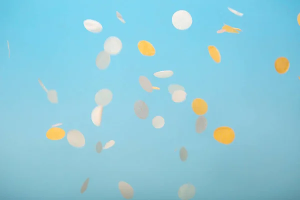 Oranje en geel vallende confetti op blauw — Stockfoto