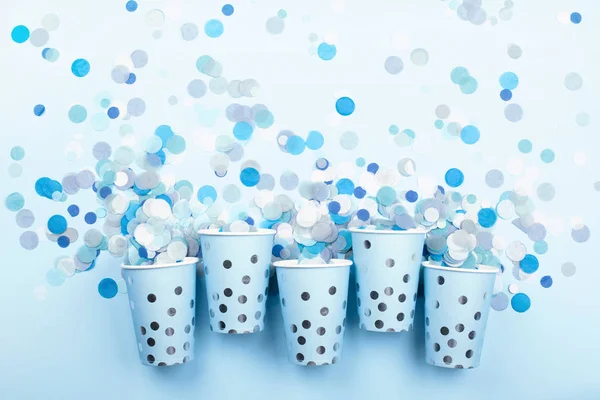 Belles tasses festives avec confettis colorés sur fond bleu pastel . — Photo