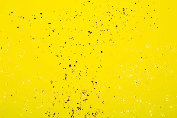 Brillos voladores dorados sobre fondo amarillo brillante . — Foto de Stock