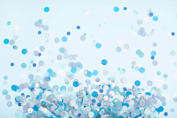 Buntes festliches Konfetti auf blauem Pastell-Hintergrund. — Stockfoto
