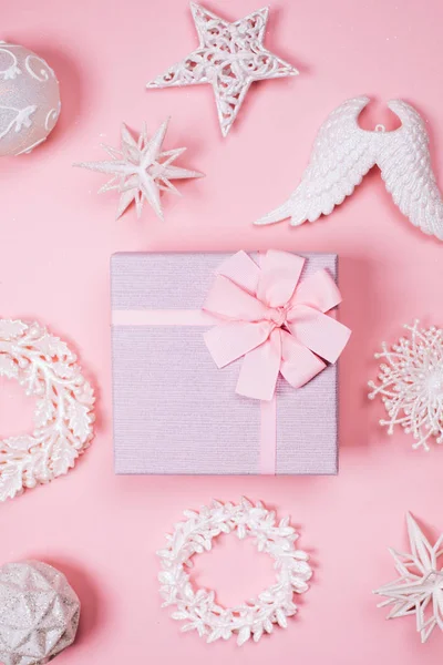 Pastel geschenkdoos met verschillende witte kerst speelgoed op roze achtergrond. — Stockfoto