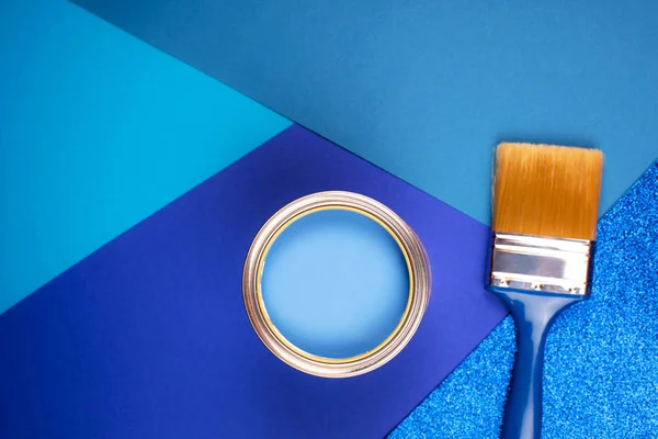 Penseel op open blik blauwe verf op blauwe ondergrond. — Stockfoto